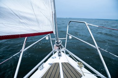 Yelkenli sporu. Kürsü, trampet, yat pruvasında önayak. Dramatik dalgalı denizde yat.