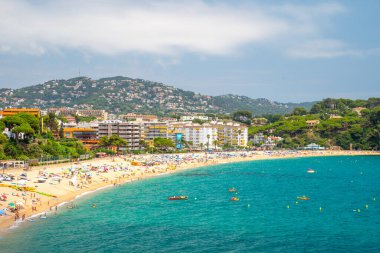 Lloret de mar, İspanya - 18 Temmuz 2019: güneşli bir günde şehir plajı. Turkuaz suyu ve denizde yüzen turistlerle dolu güzel bir koy..