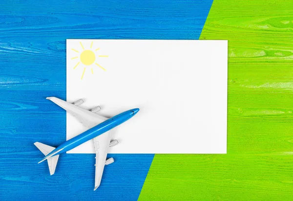 模型的飞机和空白纸在蓝色和绿色的木质背景 旅游理念 创意设计 — 图库照片