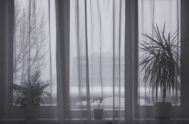 Karla kaplı şehrin penceresinden görün. Ev konforu ve sıcaklığı konsepti.