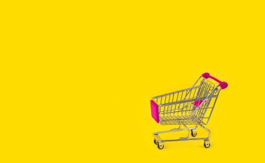 Sarı arka plan ve bazı kopya alanı üzerinde alışveriş arabası.