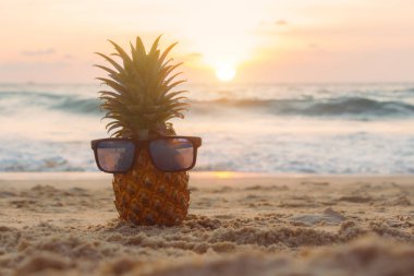 Gün batımında tropik plajda olgun ananas. Tatil ve toplam