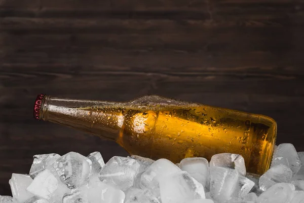 木制底座上的冰块里盛满了啤酒 图库图片