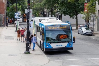 Montreal, Kanada - 4 Temmuz 2025: İnsanlar şehir merkezinde halk otobüsüne biniyor
