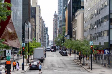 Montreal, Kanada - 4 Temmuz 2025: Yazın şehir merkezinde, binalar, arabalar ve yürüyen insanlarla dolu şehir manzarası