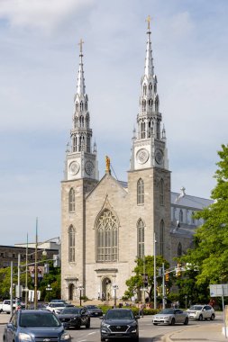 Ottawa, Kanada - 13 Haziran 2025: Şehir merkezindeki Notre-Dame Katedral Bazilikası, tarihi Katolik kilisesi ve başkent trafiği ile birlikte başkent