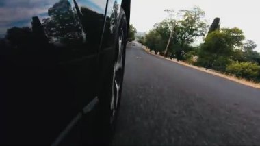 Yol asfalt yolda bir tepeden aşağı şehre sürüş ön sağ tekerlek karşı karşıya gelen araba Pov