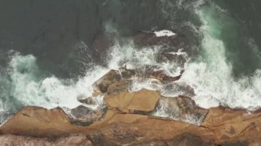 Dalgaların üzerinde kırma havadan görünümü ilginç dokular ve renkleri gösterilen kayalar