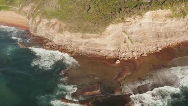Vue aérienne des vagues se brisant sur les rochers montrant des textures et des couleurs intéressantes 