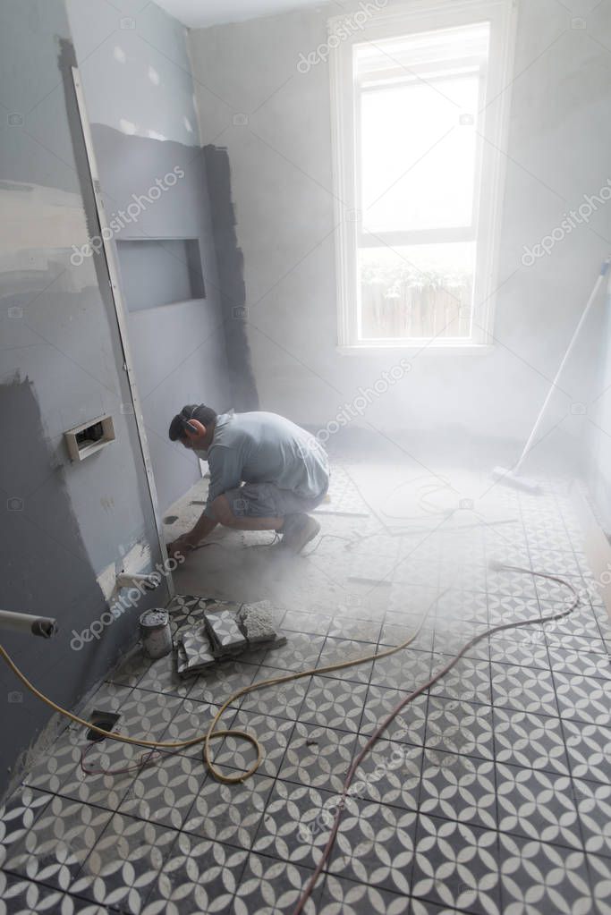 Commencing the grinding of the concrete slab in the bathroom to continue laying down tiles