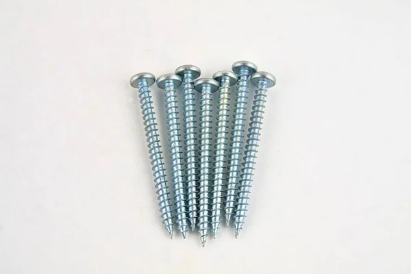 Screws for construction on a white background, metal screw, iron screw, chrome screw, screws as a background, wood screw. Close-up — Stock Photo, Image