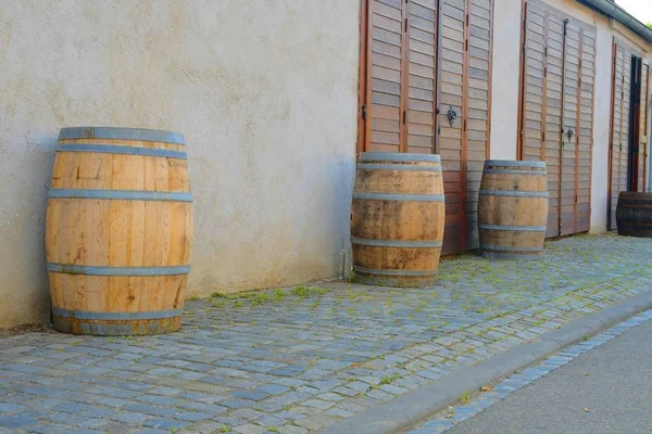 Vecchie botti di vino rustico di fronte alla moderna cantina. Il retroterra del vino in Europa. Repubblica ceca, Moravia meridionale — Foto Stock