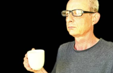 Beyaz bir bardak tutan gözlük ile orta yaşlı adam. Siyah arka planda olgun adam portresi. Boşluk Kopyala