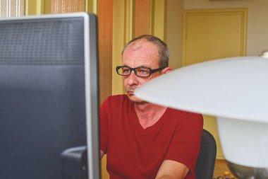 Orta masa başında oturan gözlüklü adam yaşlı. Kişisel bilgisayar kullanan olgun adam. Üst düzey kavramı