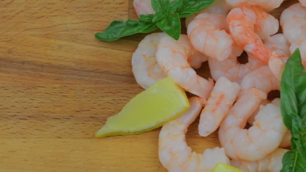 Vařené a oloupané krevety s plátky citronu a lístky bazalky na prkénko. Potravin video. Zdravé jídlo. Bio recept — Stock video