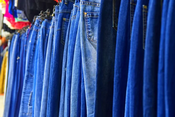一排挂在商店里的蓝色牛仔裤 服装店 在时装商城购物 衣架上的衣服 模糊视图 Defocuded — 图库照片