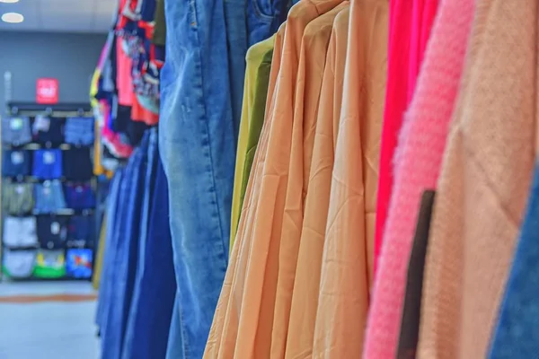 Clothes shop Costume dress. Fashion store. Style Concept. Colorful women\'s dresses on hangers in a retail shop. Fashion and shopping concept. Blurred view, defocuded.
