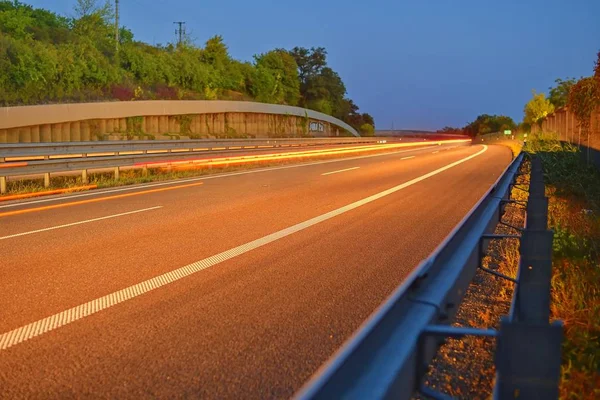 在黄昏的高速公路与光小径 高交通道路与汽车光足迹 — 图库照片