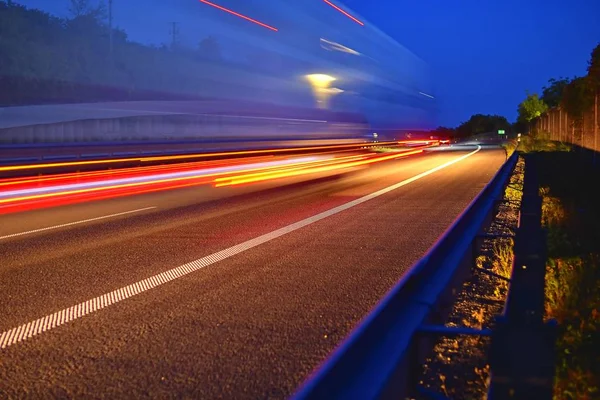 在高速公路上进行运输和物流的卡车晚间拍摄 公路交通 运动模糊卡车在高速公路 机动车路 高速公路在黄昏 — 图库照片