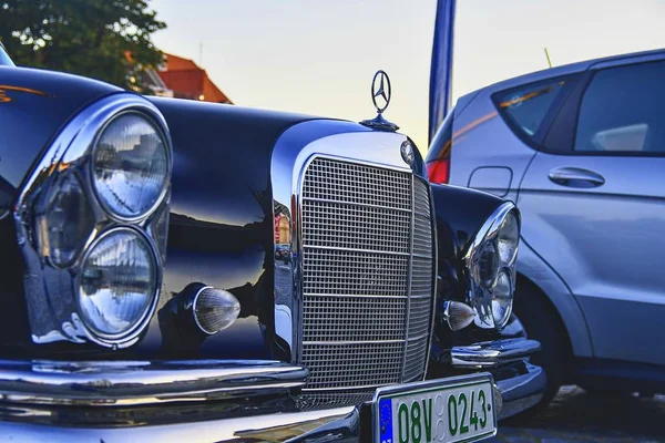 Logo de Mercedes Benz en un coche vintage negro. Primer plano. Mercedes-Benz es un fabricante de automóviles alemán. La marca se utiliza para automóviles de lujo, autobuses, autocares y camiones . —  Fotos de Stock