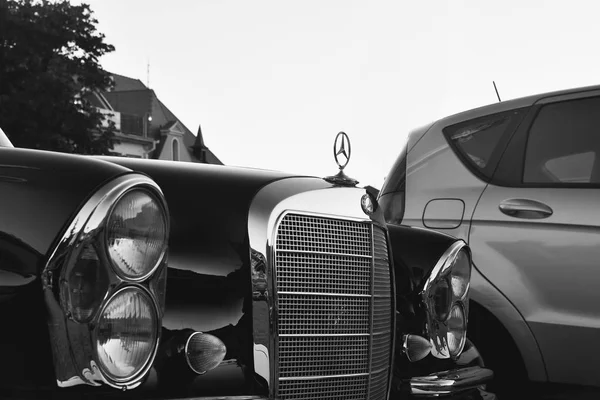 Логотип Мерседес Бенц на черной винтажной машине. Mercedes-Benz - немецкий производитель автомобилей. Бренд используется для роскошных автомобилей, автобусов, автобусов и грузовых автомобилей. Чёрный белый фильтр . — стоковое фото