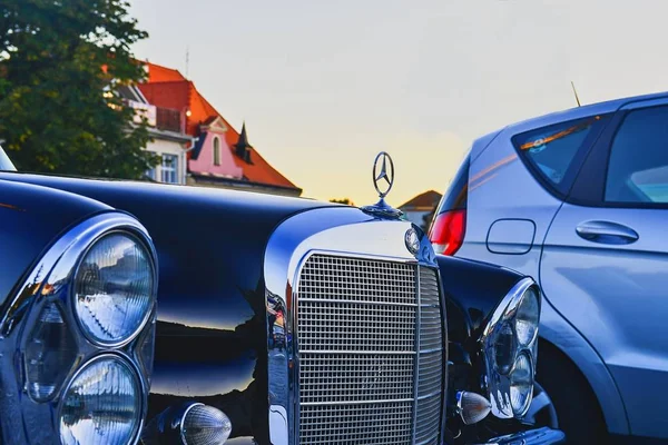 Mercedes Benz logo na czarnym rocznika samochodu. Mercedes-Benz jest niemiecki producent samochodów. Marka jest używany dla luksusowych samochodów, autobusów i ciężarówek. — Zdjęcie stockowe