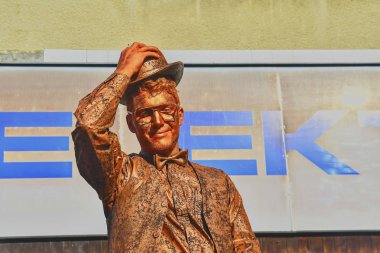 Hustopece, Çek Cumhuriyeti - 7 Ekim 2018: Cupreous boyalı sanatçı yaşam heykel gibi beyefendi gibi giyinmiş. Yaşam ciddi adam heykeli. Canlı heykel sokak icracı. Canlı heykel sanatçıları geçenler aptal ve turistleri eğlendirmek.