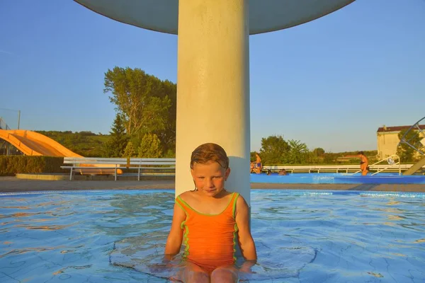 Bir Yağmurlama Yüzme Havuzunda Duş Altında Oturan Küçük Kız Yüzme — Stok fotoğraf