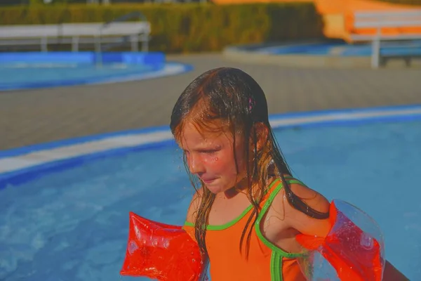 スイミング プールで夏の日を楽しんで幸せな女の子 小さなスイミング プール 膨脹可能なアームバンドとかわいい女の子 夏と幸せ Chilhood コンセプト — ストック写真