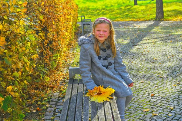 Küçük Kız Retro Bir Palto Giyiyor Sonbaharda Parkta Bankta Oturmuş — Stok fotoğraf