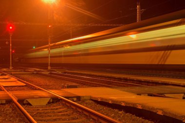 Beyaz ve mavi bir küçük roofless tren istasyonunda gece Çek Cumhuriyeti'nde geçen tren. Bulanık hareket Tren