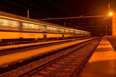Beyaz ve mavi bir küçük roofless tren istasyonunda gece Çek Cumhuriyeti'nde geçen tren. Bulanık hareket Tren