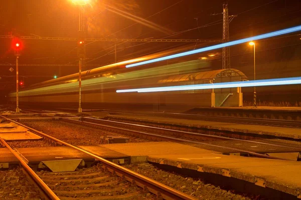 Beyaz ve mavi bir küçük roofless tren istasyonunda gece Çek Cumhuriyeti'nde geçen tren. Bulanık hareket Tren