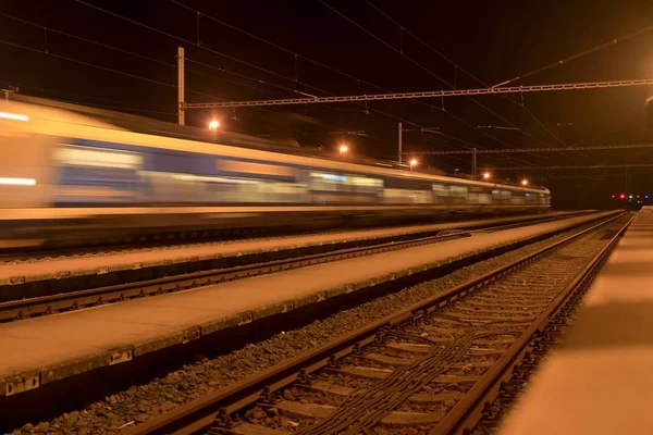 Hochgeschwindigkeits-Personenzug auf Gleisen mit Bewegungsunschärfeeffekt nachts. Bahnhof in der Tschechischen Republik — Stockfoto