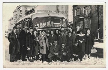 Retro Fotoğraf bir grup insan önünde otobüs poz gösterir. İnsanlar kış gezisi sırasında. Siyah beyaz fotoğraf.