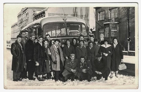 Retro kép azt mutatja, hogy egy embercsoport póz az első busz. Az emberek téli utazás közben. Vintage fekete-fehér fotózás. — Stock Fotó