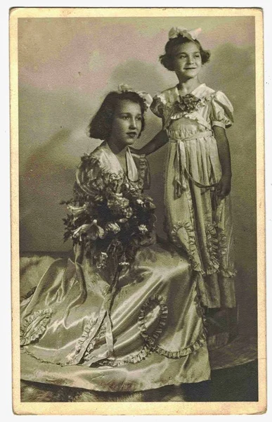 Foto retrô mostra meninas posando no estúdio de fotos. Meninas vestindo trajes festivos. Vintage preto e branco fotografia . — Fotografia de Stock