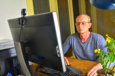 Bir ofiste oturan işadamı. Orta masa başında oturan gözlüklü adam yaşlı. Cep telefonu kullaranarak olgun adam. Üst düzey kavramı.