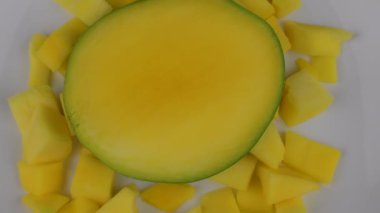 Organik tropikal meyve, beyaz plaka üzerinde slaytlar Mango kapatın. Shift odaklanmak ve döndürme