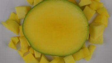 Organik tropikal meyve, beyaz plaka üzerinde slaytlar Mango kapatın. Shift odaklanmak ve döndürme