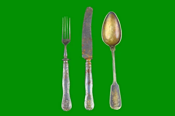 Vintage cutlery on a green background. Top view. Crazy concept for culinary and modern life. Contrast between shabby cutlery and excellent modern color. Free space for text — Stock Photo, Image