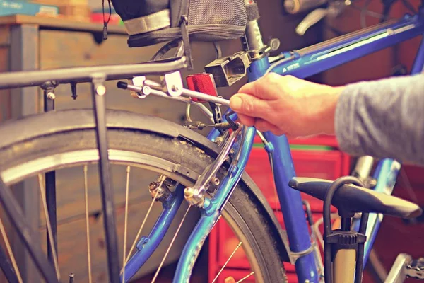 Synvinkel manliga mekanik händer reparera cykeln med hjälp av specialverktyg. Selektivt fokus — Stockfoto