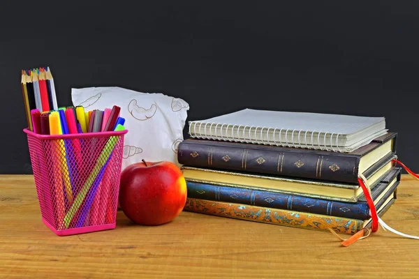 Έννοια της Σχολής lunch break με μήλο και σχολικών ειδών στο ξύλινο γραφείο, επιλεκτική εστίαση. Βιβλία, μαρκαδόροι και μολύβια χρώματος τονίζοντας την έννοια. Ώρα για μελέτη και να χαλαρώσετε. — Φωτογραφία Αρχείου