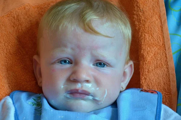 A alimentar a filhinha engraçada e feliz. Retrato bebê miserável na cama em seu quarto — Fotografia de Stock