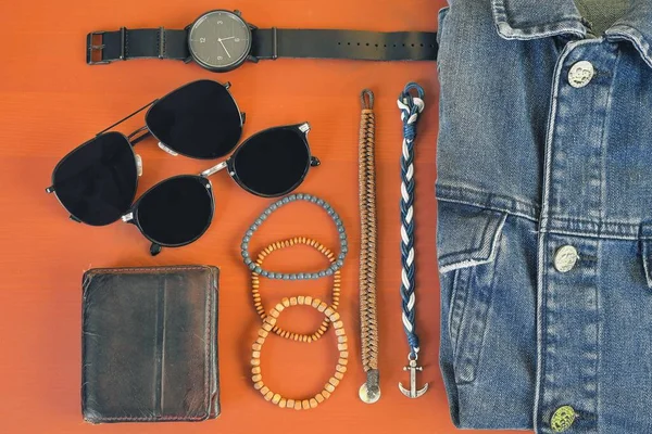 Vista superior dos acessórios masculinos. Hipster ou conceito de homem moderno. Acessórios para dar um passeio. Acessórios de moda masculina, flat lay no fundo rosa coral. Carteira, pulseiras, óculos de sol - sombras, relógio — Fotografia de Stock