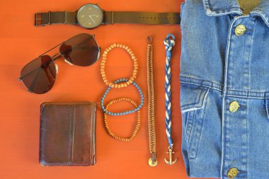 Erkek aksesuarlarının en üst görüntüsü. Hipster ya da modern insan konsepti. Yürüyüşe çıkmak için aksesuarlar. Erkek moda aksesuarları, mercan pembe arka planda düz yatar. Cüzdan, bilezik, güneş gözlüğü - güneş gözlüğü, saat
