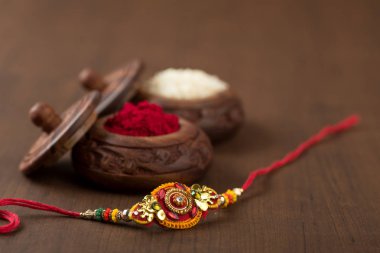 Hint festivali: Raksha Bandhan özgeçmişi zarif bir Rakhi, pirinç taneleri ve Kumkum ile. Geleneksel Hint bilekliği Kardeşler ve Kız Kardeşler arasındaki aşkın sembolüdür..