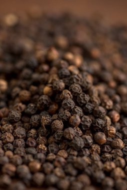 Ahşap arka planda siyah biber ya da karabiber yakın plan.