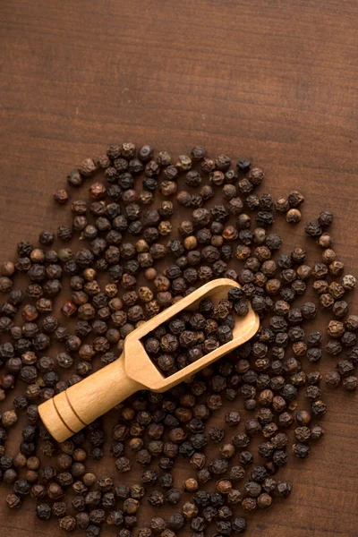 木背木勺上的黑胡椒或胡椒粉的特写 — 图库照片