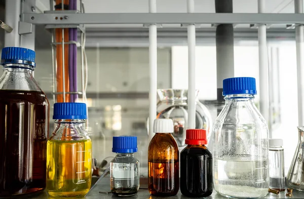 Biyokimya deneyleri için stok çözümleri, farklı renkte kapaklı şişeler raflarda, bulanık arka planda